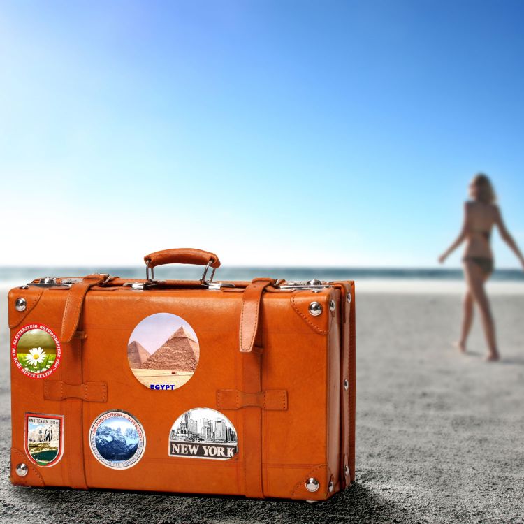 Une valise est posée sur la plage près d'une baigneuse