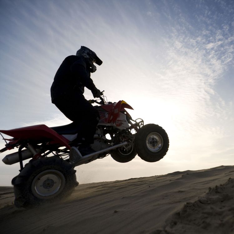 Personne sur un véhicule tout-terrain dans une dune de sable